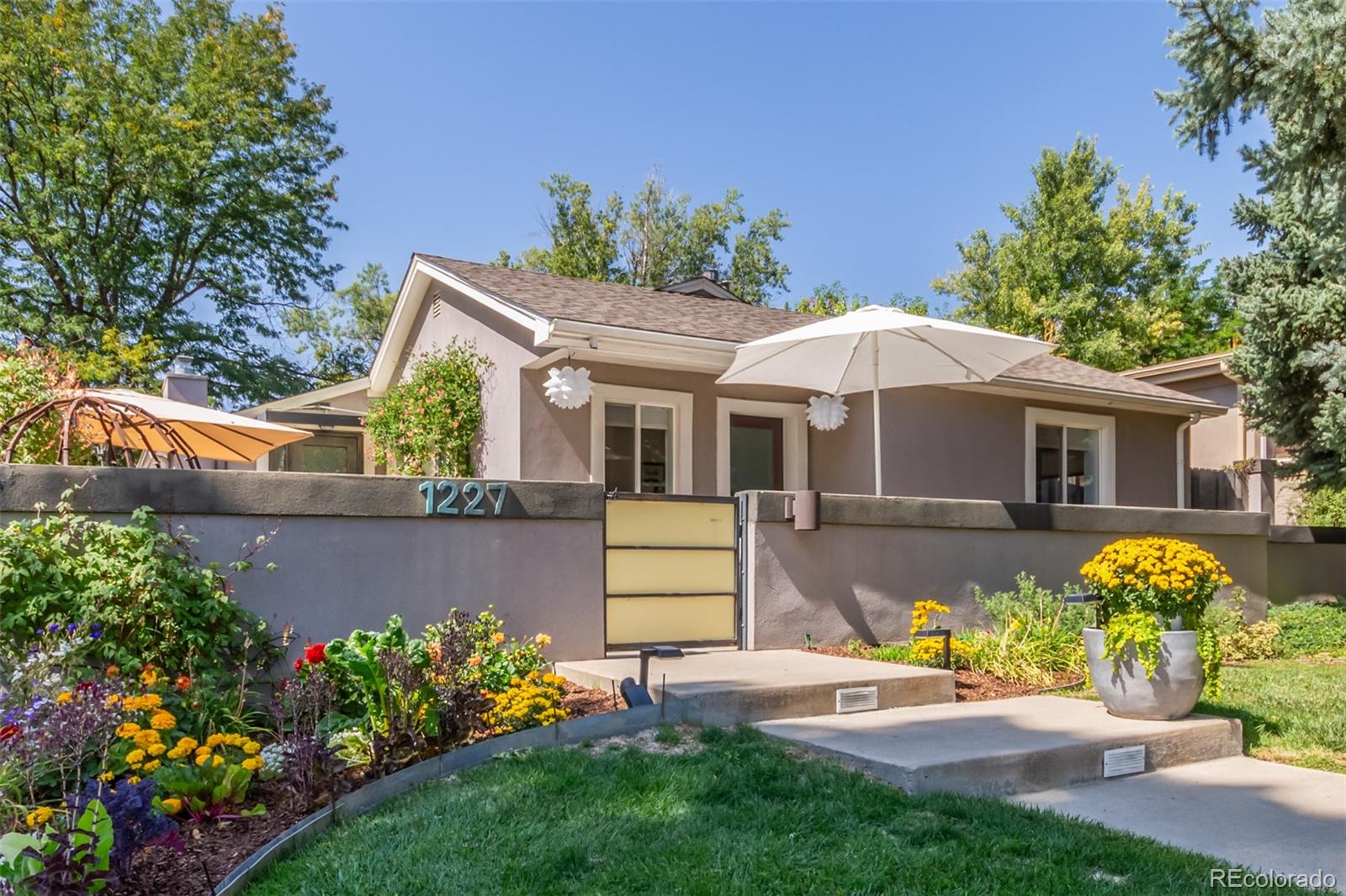 1227 Elm Street Denver, CO 80220 - Photo 2 of 44 a front view of a house with a yard and fountain