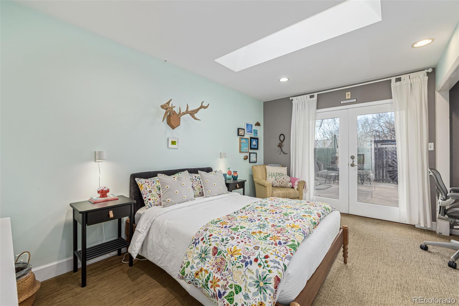 1227 Elm Street Denver, CO 80220 - Photo 24 of 44 a bedroom with a large bed and a chandelier