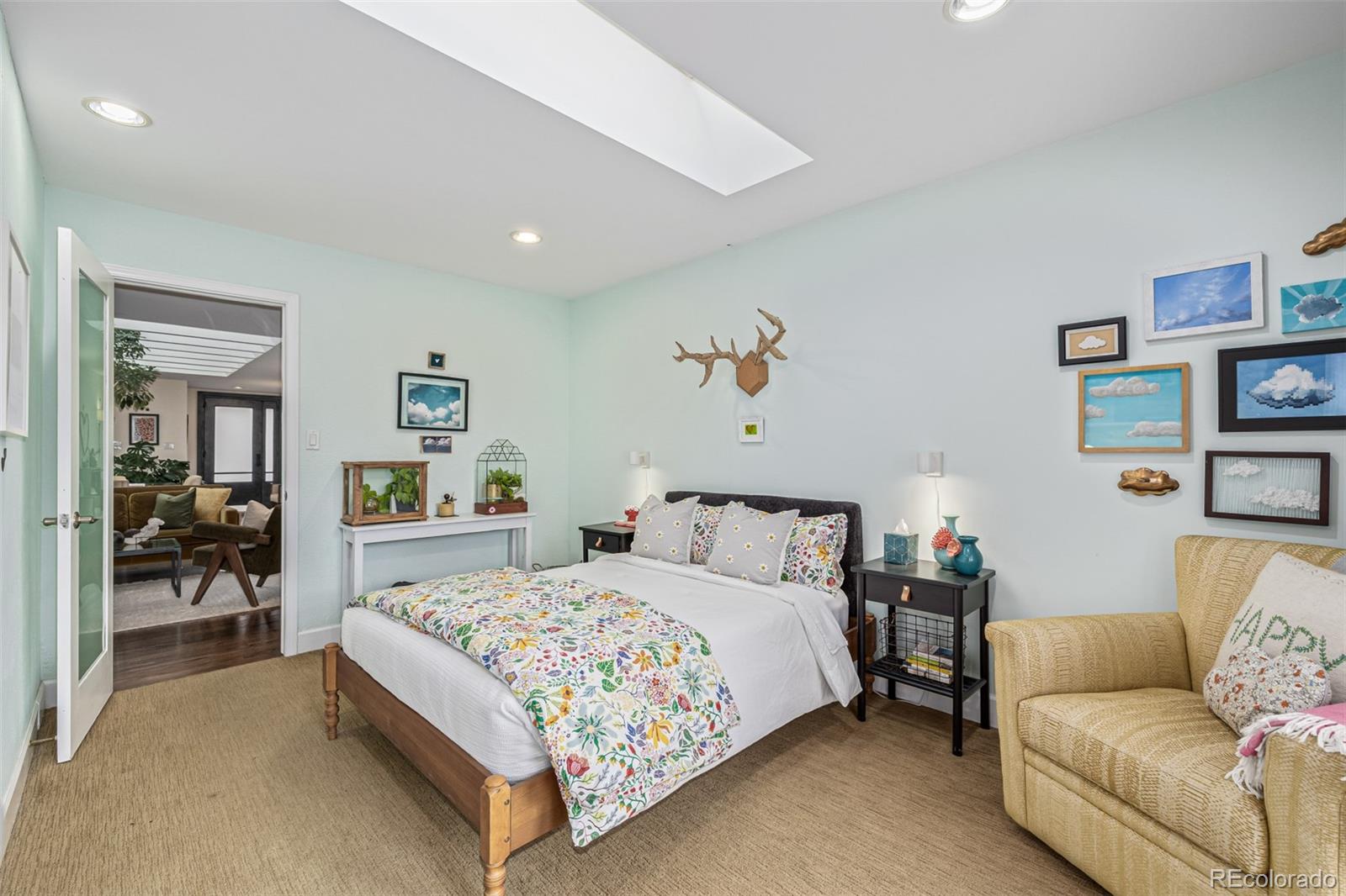 1227 Elm Street Denver, CO 80220 - Photo 25 of 44 a bedroom with a bed couch and painting on the wall