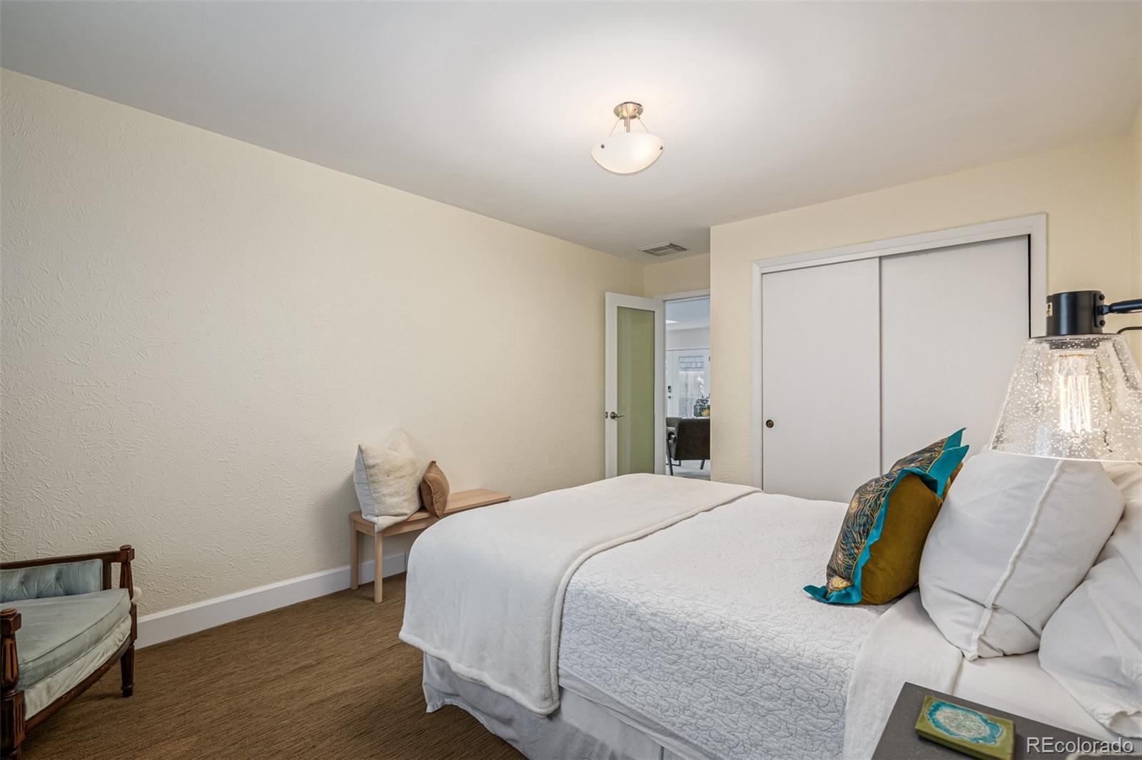 1227 Elm Street Denver, CO 80220 - Photo 28 of 44 a bedroom with a bed and wooden floor