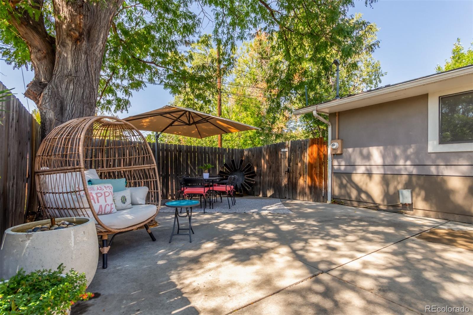 1227 Elm Street Denver, CO 80220 - Photo 38 of 44 a view of a chairs and table in the back yard of the house