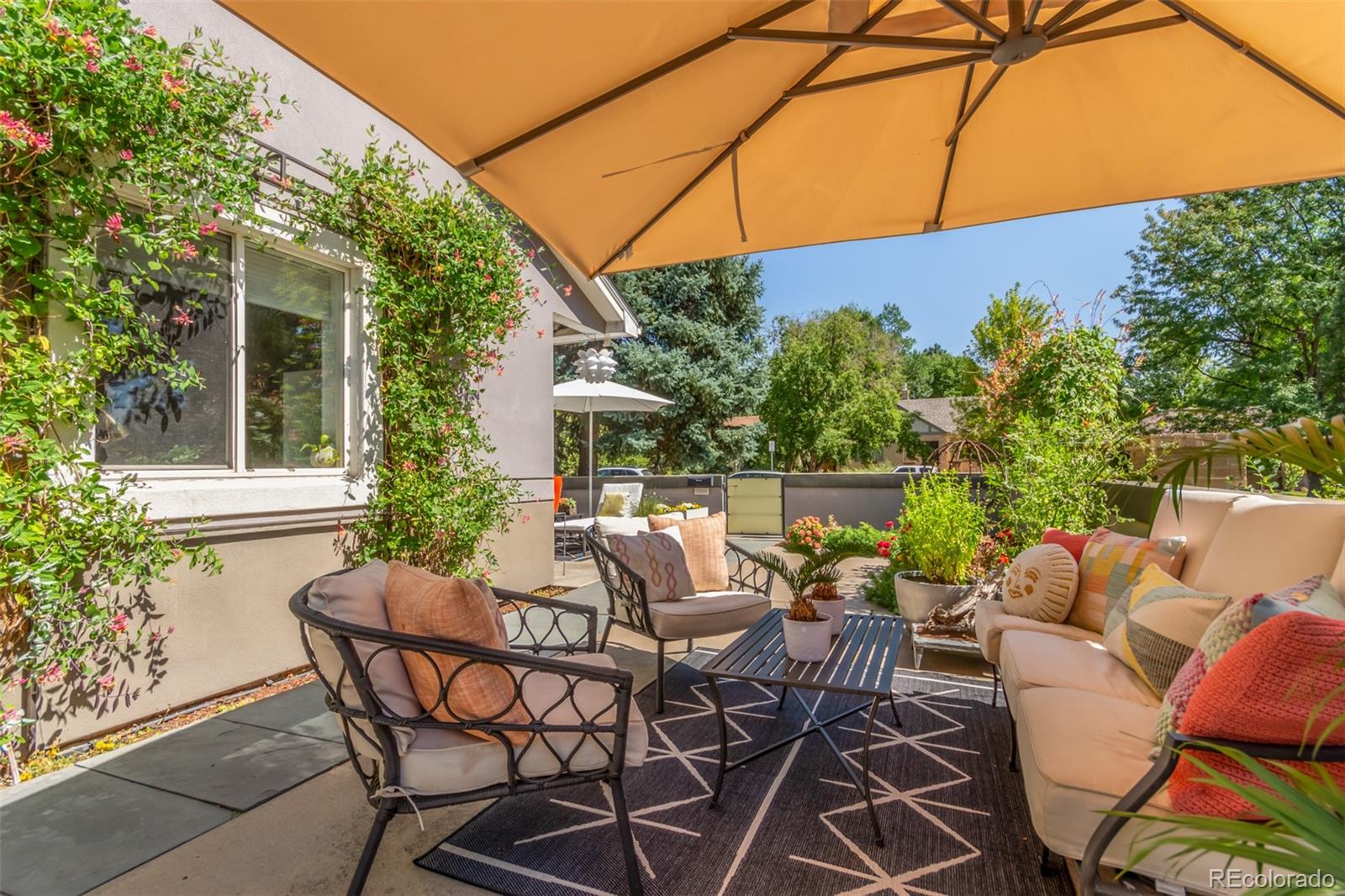1227 Elm Street Denver, CO 80220 - Photo 40 of 44 a view of a patio with a table and chairs under an umbrella