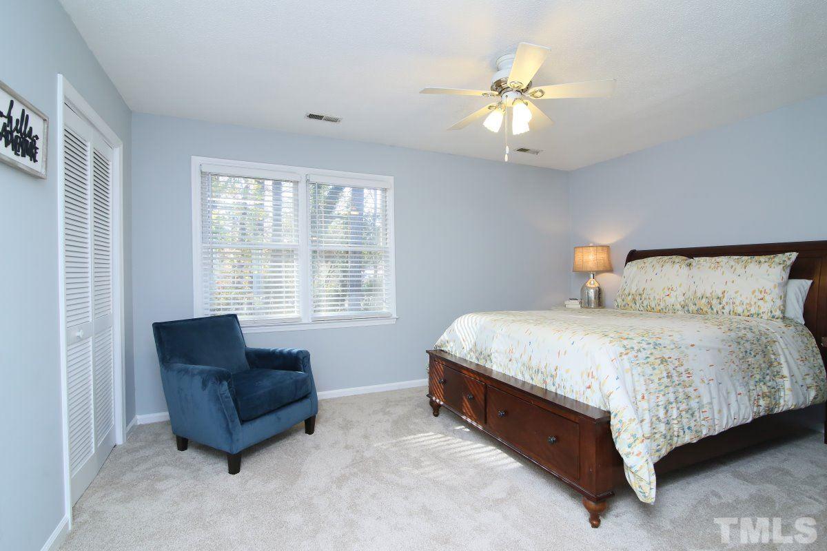 5649 Hamstead Crossing Raleigh, NC 27612 - Photo 13 of 25 a spacious bedroom with a bed and a couch