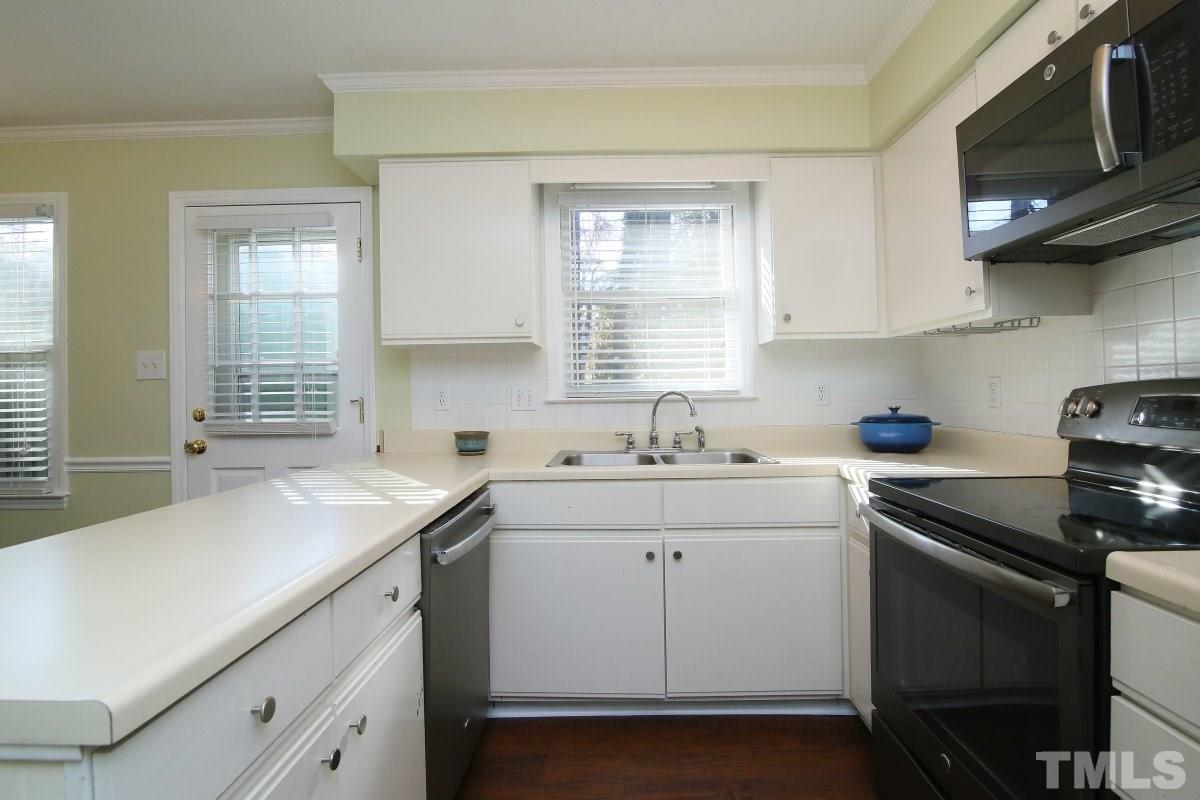 5649 Hamstead Crossing Raleigh, NC 27612 - Photo 9 of 25 a kitchen with stainless steel appliances granite countertop a sink dishwasher a stove and a microwave oven with cabinets