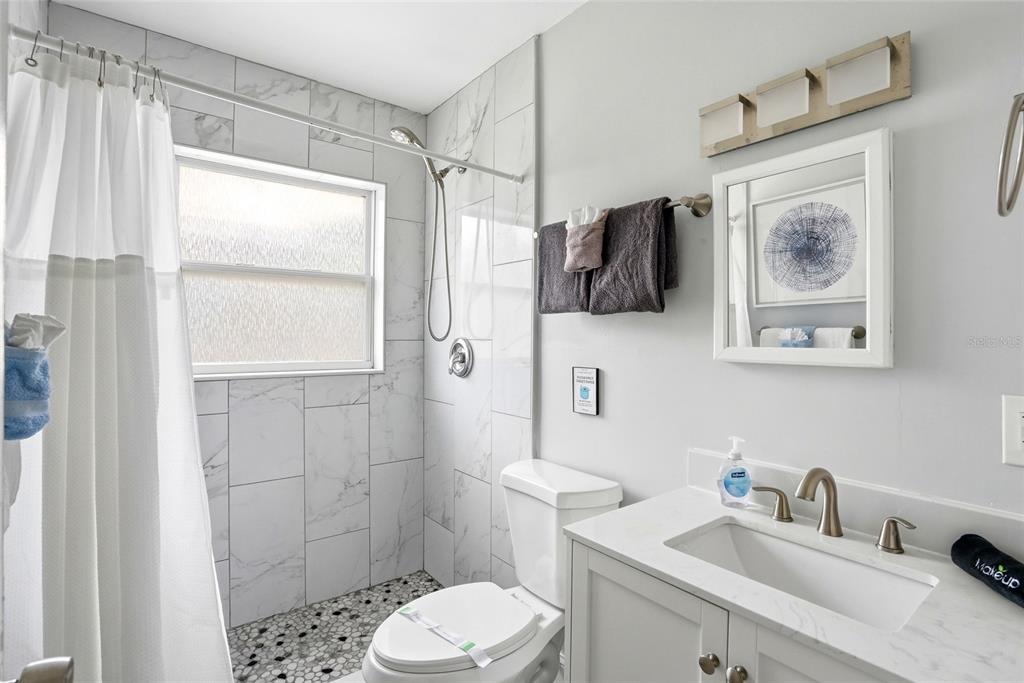 2311 Bay Boulevard Indian Rocks Beach, FL 33785 - Photo 36 of 80 a bathroom with a sink toilet and shower