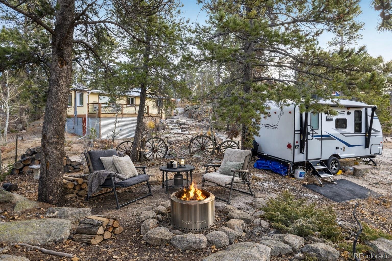 24 Signal Rock Road Golden, CO 80403 - Photo 24 of 26 a backyard of a house with barbeque oven table and chairs