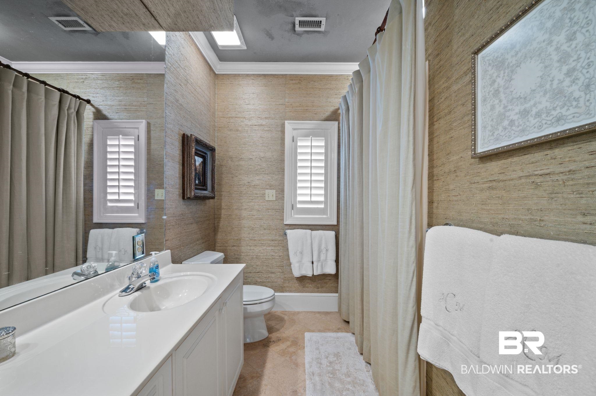 31800 River Road Orange Beach, AL 36561 - Photo 36 of 69 Bathroom with a wealth of natural light, crown molding, vanity, and toilet