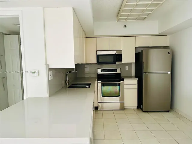 a kitchen with a refrigerator and a stove top oven
