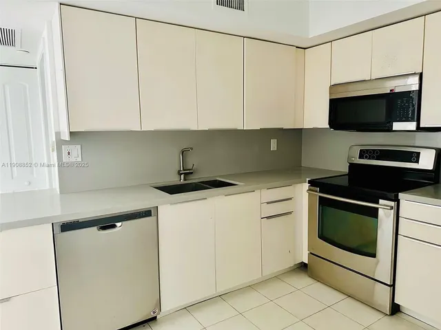 a kitchen with white cabinets and stainless steel appliances