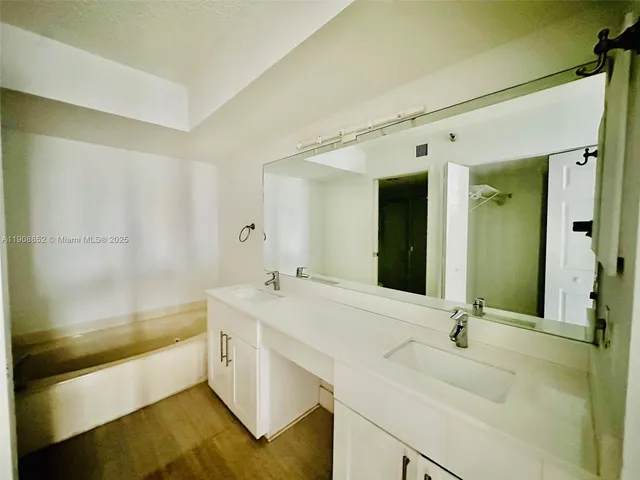 a bathroom with a tub sink and mirror