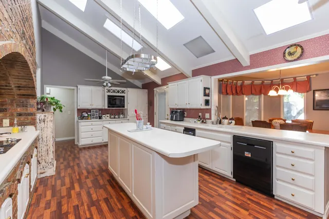 a front view of a house with garden and trees
