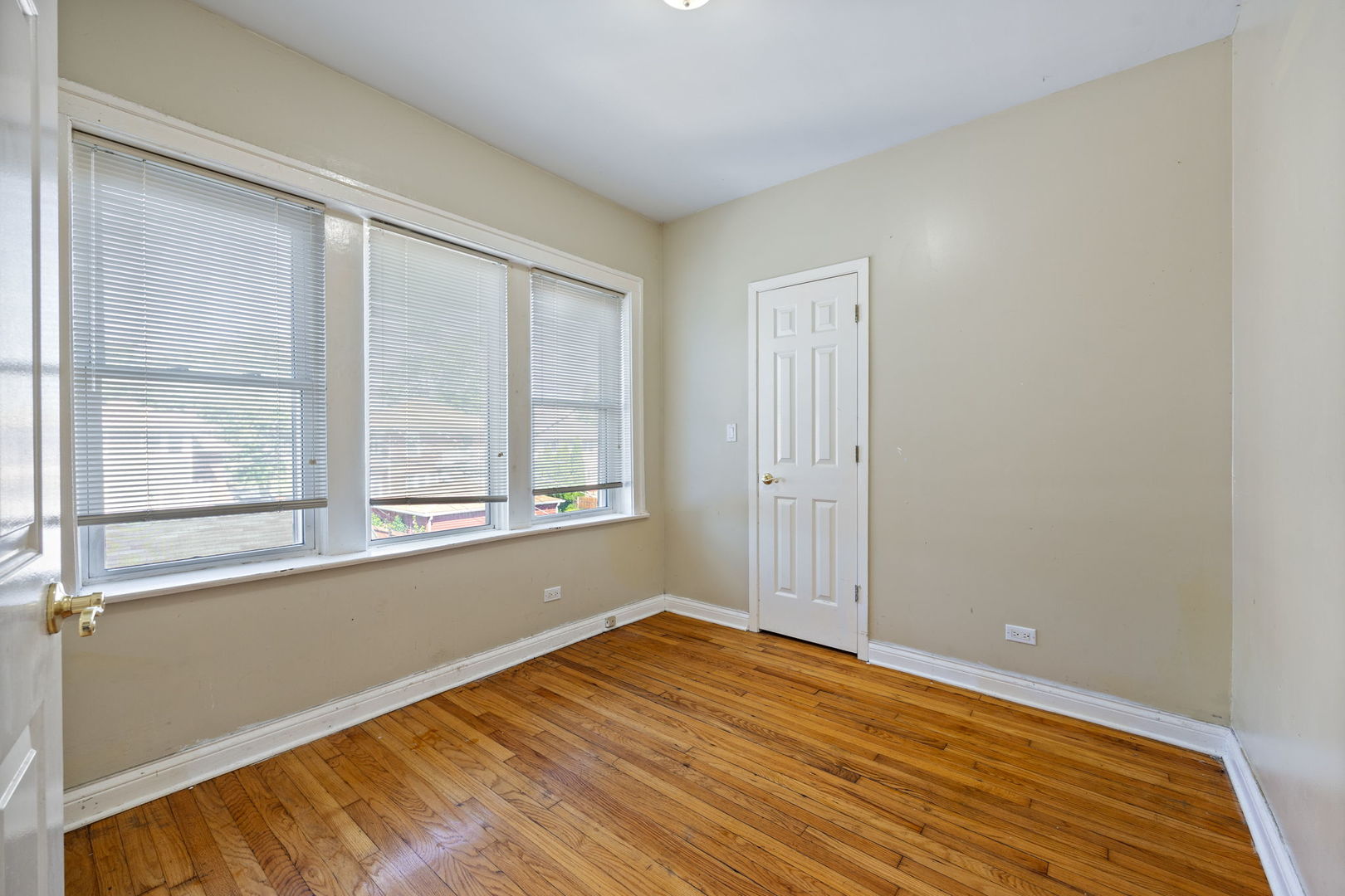 7416 South Yates Boulevard, Unit 2 Chicago, IL 60649 - Photo 15 of 16 a view of an empty room with wooden floor and a window