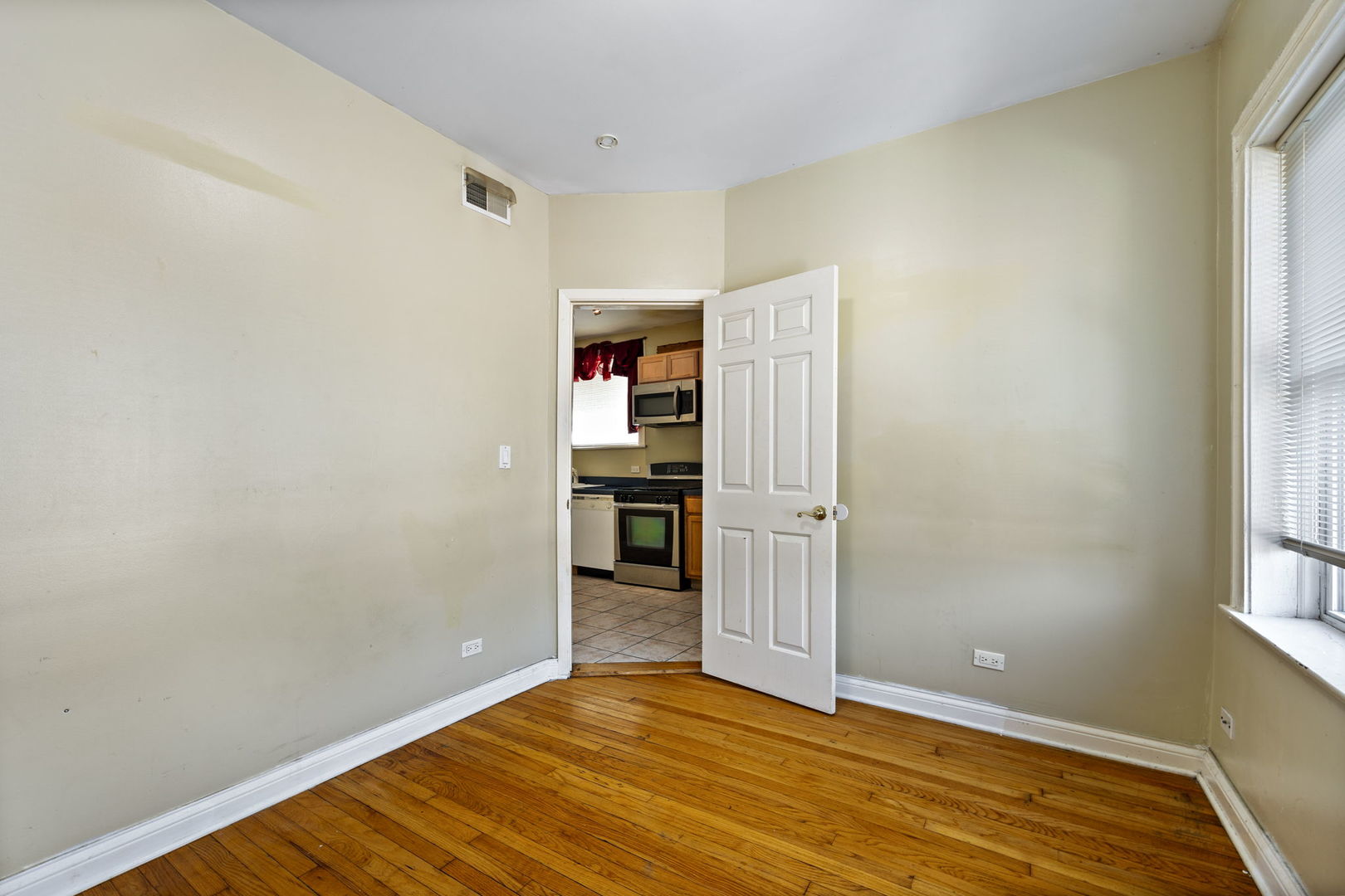 7416 South Yates Boulevard, Unit 2 Chicago, IL 60649 - Photo 16 of 16 an empty room with wooden floor closet and windows