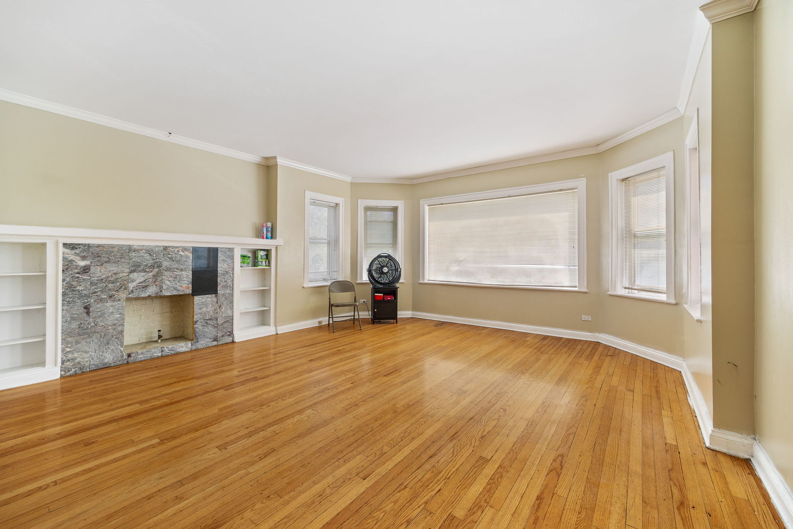 7416 South Yates Boulevard, Unit 2 Chicago, IL 60649 - Photo 2 of 16 a view of empty room with wooden floor and fan