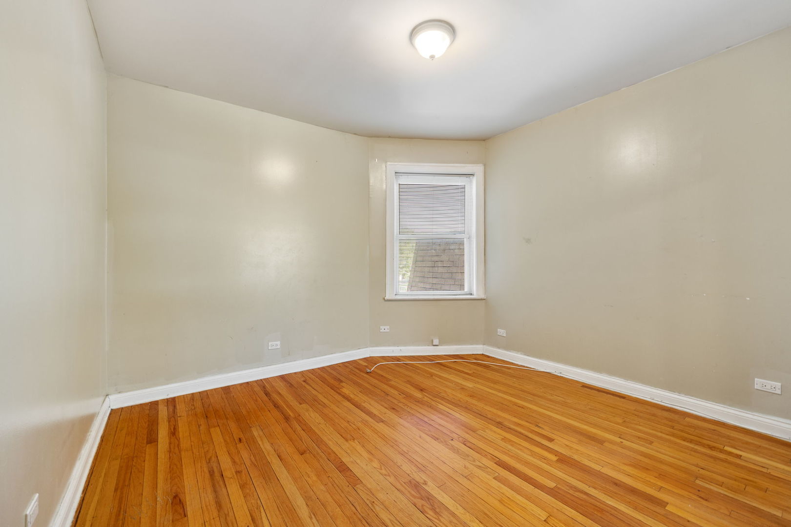 7416 South Yates Boulevard, Unit 2 Chicago, IL 60649 - Photo 10 of 16 an empty room with wooden floor and windows