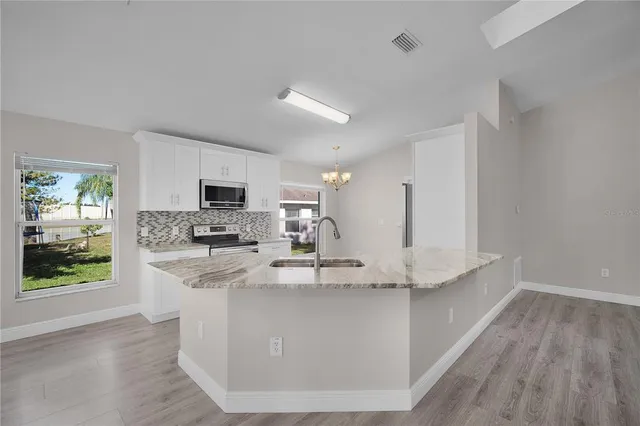 a kitchen with kitchen island white cabinets and refrigerator