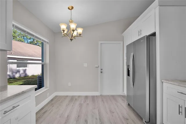 a view of a room with wooden floor fan and windows