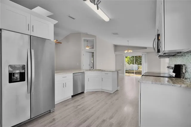 a kitchen with a refrigerator and a stove top oven