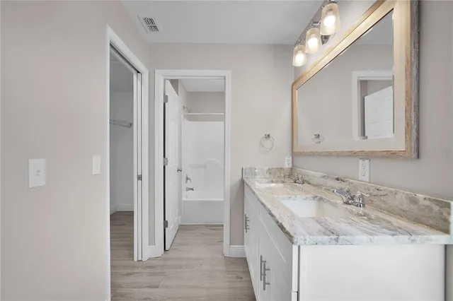 a bathroom with a granite countertop sink and a mirror
