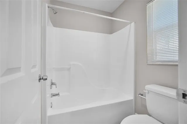 a white toilet sitting next to a bath tub