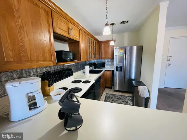 a kitchen with a refrigerator a stove and a sink