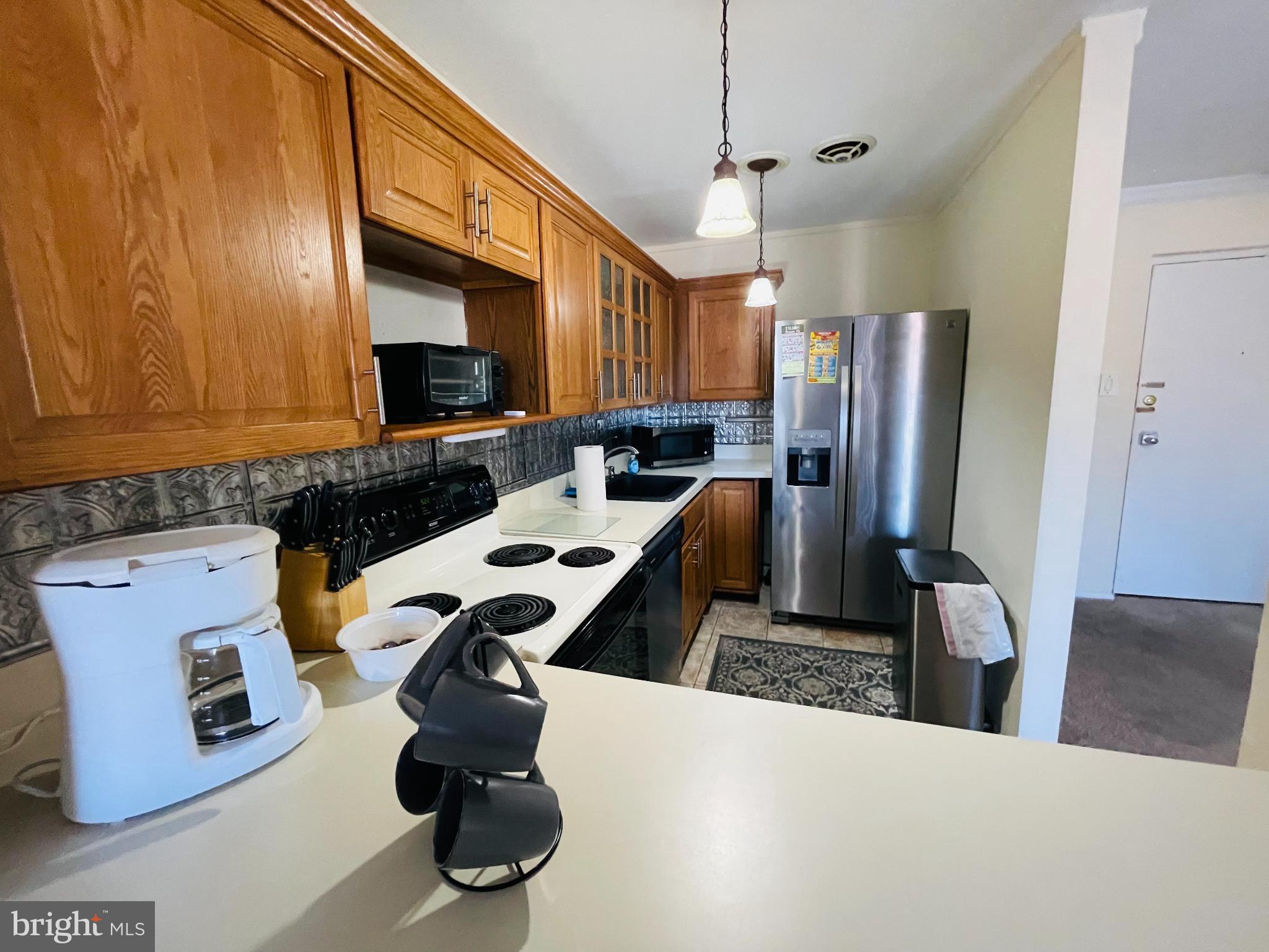 46 Township Line Road, Unit 215 Elkins Park, PA 19027 - Photo 5 of 17 a kitchen with a refrigerator a stove and a sink