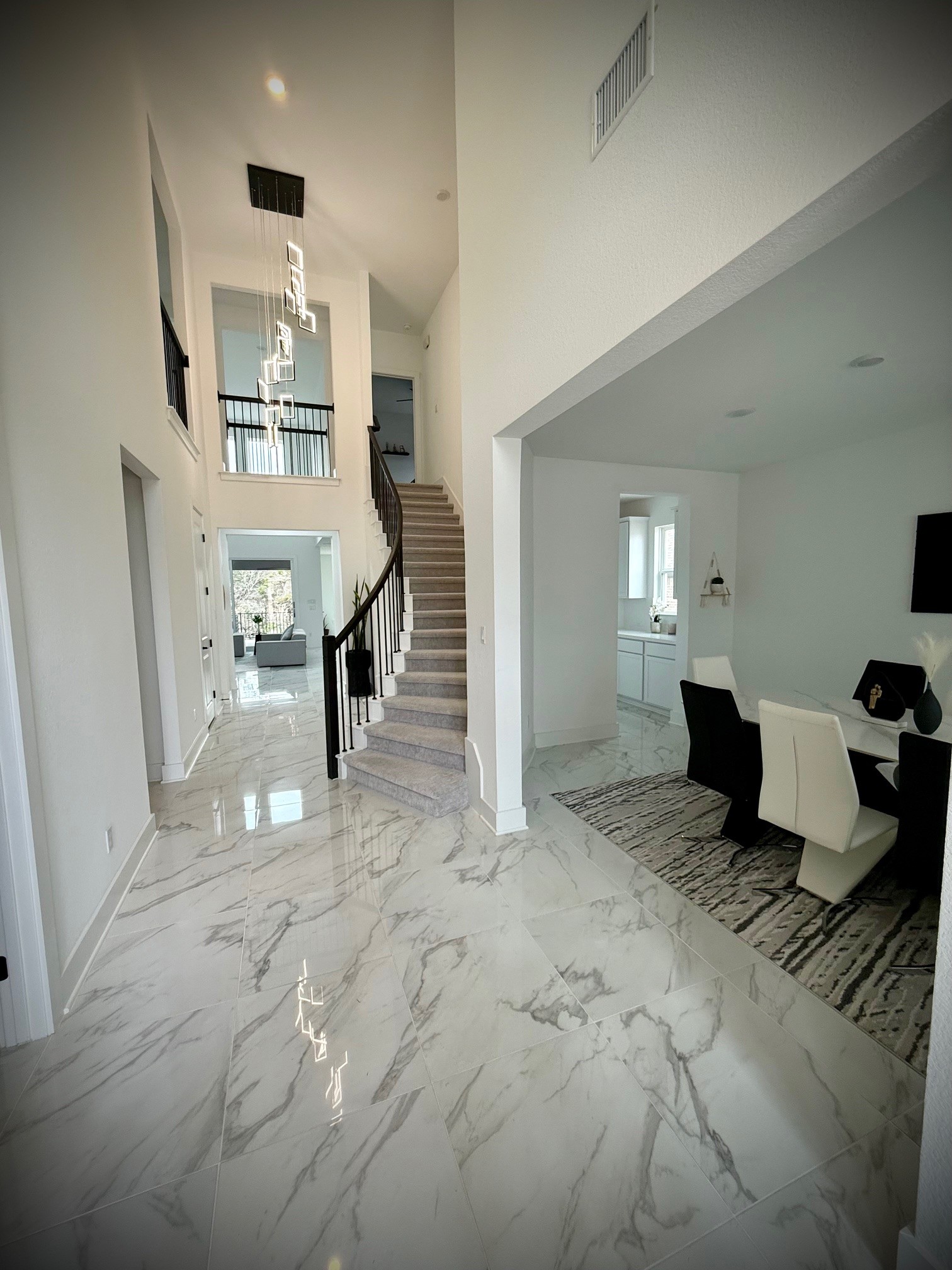 579 Jackson River Loop Kyle, TX 78640 - Photo 2 of 6 Entryway with light marble finish floors, a high ceiling, and a chandelier