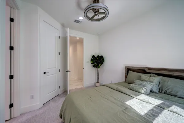 a bedroom with a large bed and a chandelier