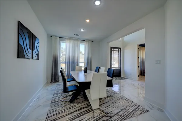 a dining room with wooden floor and white walls