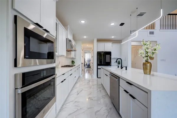 a large kitchen with stainless steel appliances kitchen island granite countertop a sink and cabinets