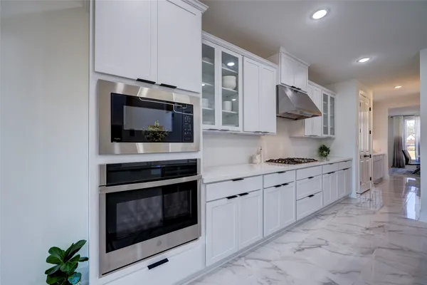 a large kitchen with stainless steel appliances granite countertop a stove and a microwave