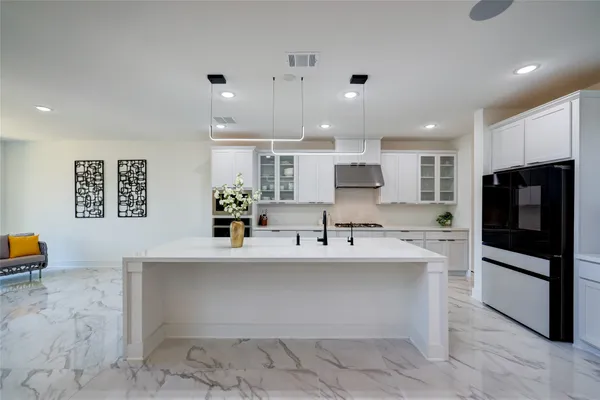 a kitchen with kitchen island a sink stainless steel appliances and cabinets
