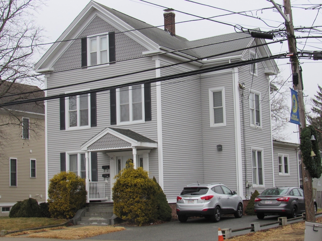 96 Main Street, Unit 1 Blackstone, MA 01504 - Photo 1 of 16 a car parked in front of a white house