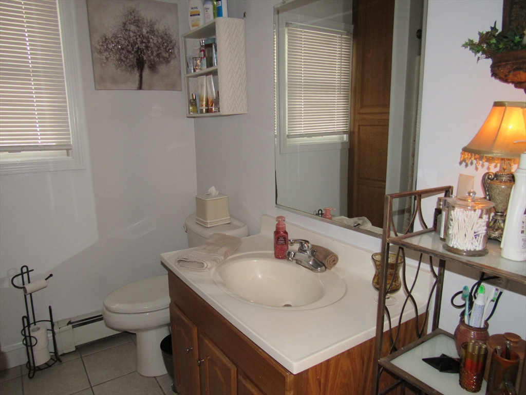 96 Main Street, Unit 1 Blackstone, MA 01504 - Photo 14 of 16 a bathroom with a sink toilet and a mirror
