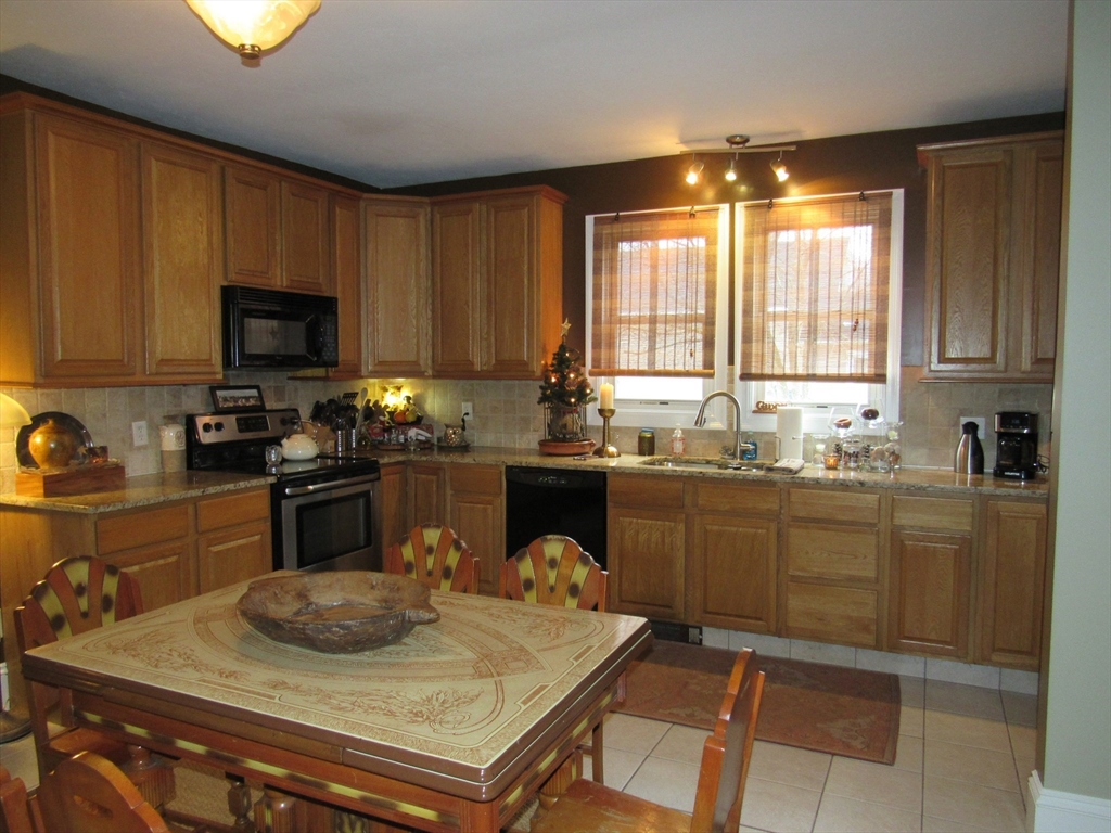 96 Main Street, Unit 1 Blackstone, MA 01504 - Photo 6 of 16 a kitchen with a stove a sink a refrigerator and cabinets