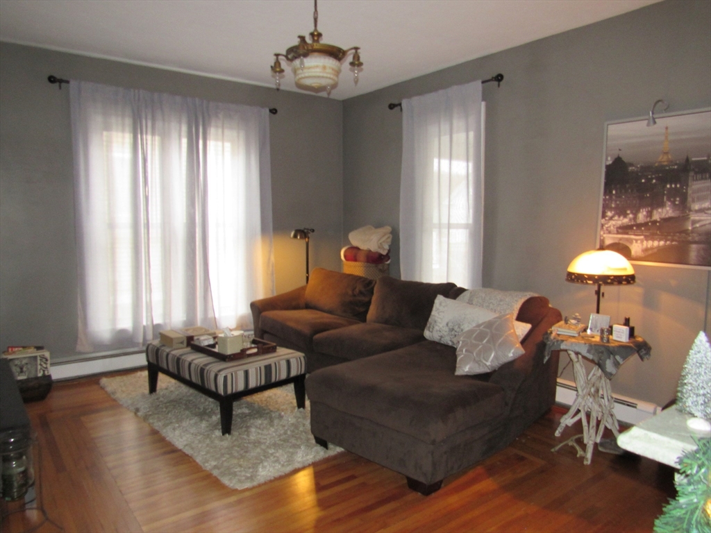 96 Main Street, Unit 1 Blackstone, MA 01504 - Photo 10 of 16 a living room with furniture and a chandelier