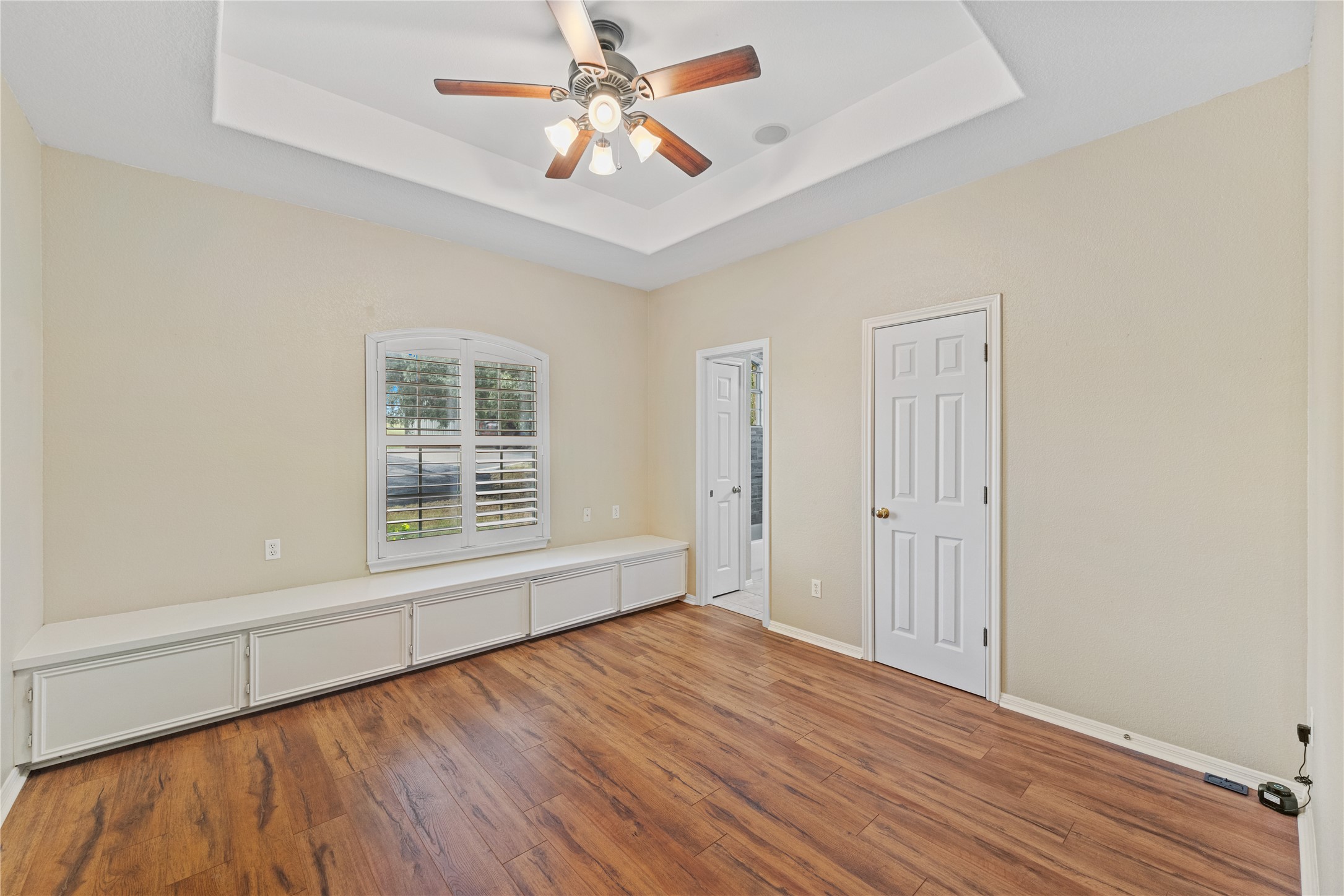 20145 Janak Road Coupland, TX 78615 - Photo 19 of 40 Secondary bedroom offers well-lit interior space features beautiful hardwood flooring and a functional built-in storage bench.