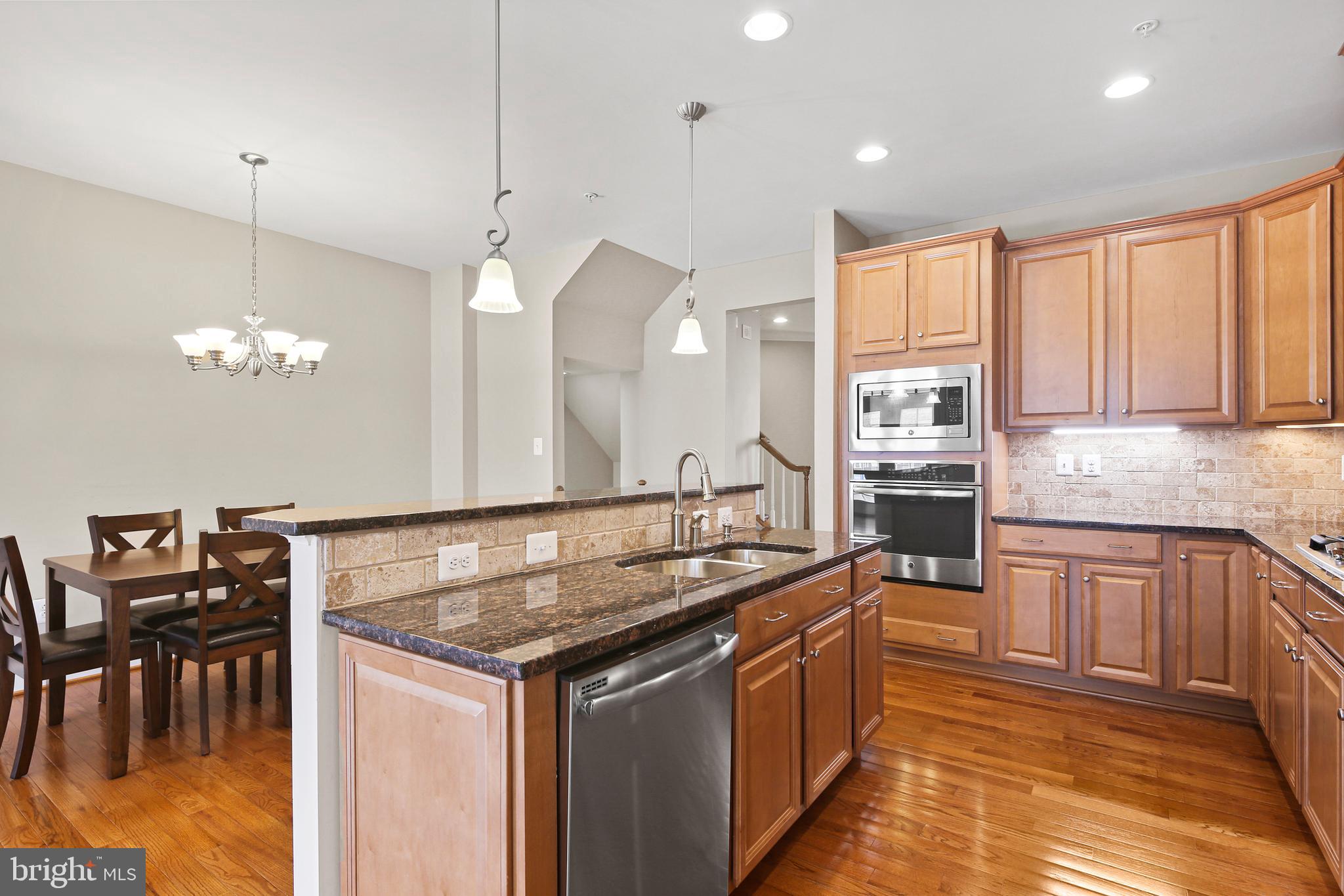 3553 Katherine Way Frederick, MD 21704 - Photo 24 of 34 a kitchen with stainless steel appliances granite countertop a sink a stove and a wooden floor