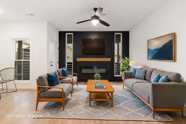 a living room with furniture a fireplace and a flat screen tv