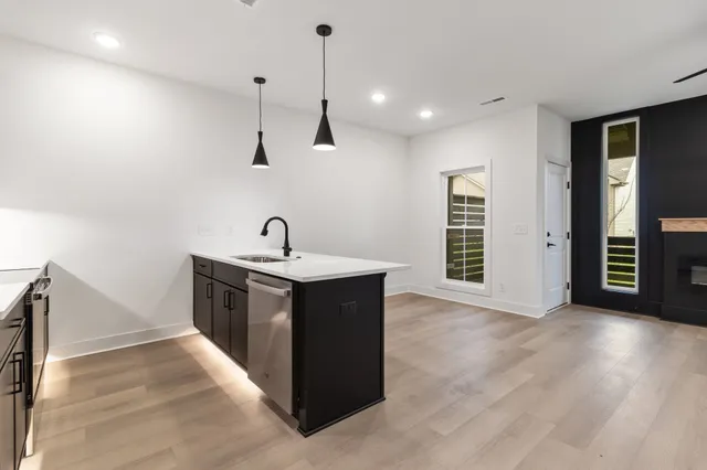 a kitchen with kitchen island a sink and a stove