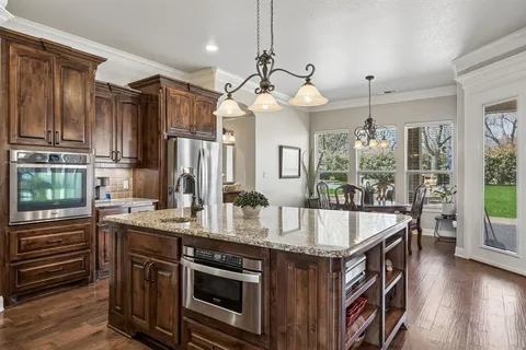 a kitchen with a table chairs sink and cabinets