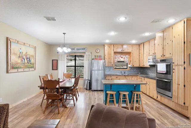 a dining room with furniture a chandelier and wooden floor