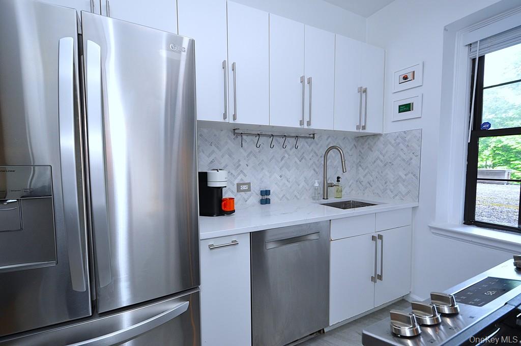 192 Garth Road, Unit TP Scarsdale, NY 10583 - Photo 10 of 43 The thoughtfully renovated kitchen is a chef’s delight, showcasing stainless steel appliances, custom white cabinetry, abundant quartz countertops, and generous workspace.