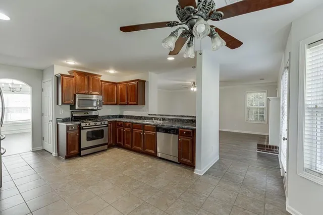 a large kitchen with stainless steel appliances granite countertop a stove and a refrigerator