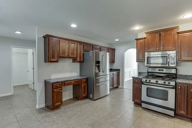 a kitchen with stainless steel appliances granite countertop a stove a refrigerator and a microwave