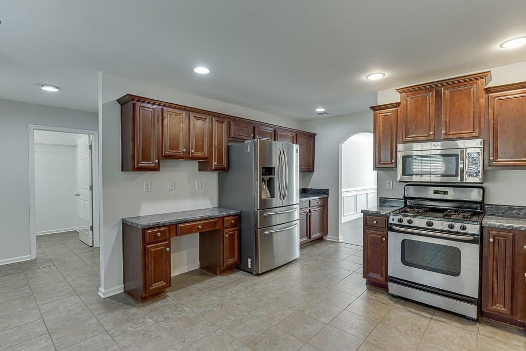 926 Red Wolf Court Dacula, GA 30019 - Photo 16 of 47 a kitchen with stainless steel appliances granite countertop a stove a refrigerator and a microwave