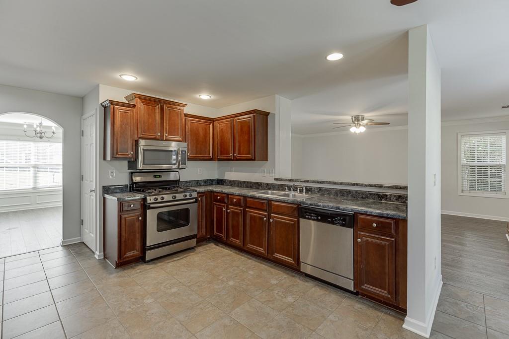 926 Red Wolf Court Dacula, GA 30019 - Photo 17 of 47 a kitchen with stainless steel appliances granite countertop a stove sink and cabinets