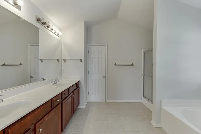 a spacious bathroom with a bathtub sink and mirror
