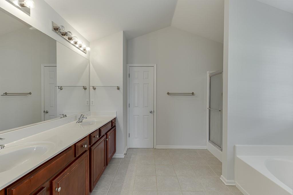 926 Red Wolf Court Dacula, GA 30019 - Photo 25 of 47 a spacious bathroom with a bathtub sink and mirror