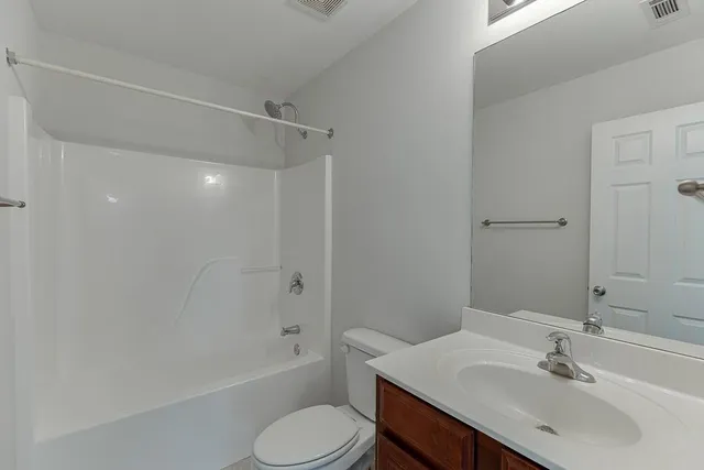 a bathroom with a sink toilet vanity and shower
